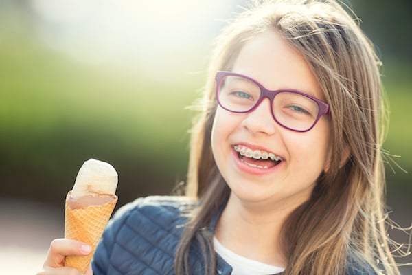 Little Girl Smiling With Braces Eating Ice Cream