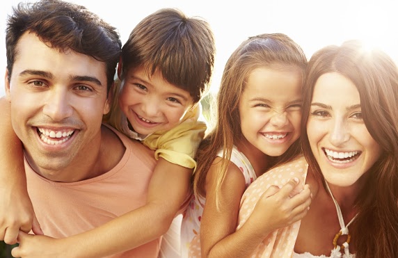 Mother, father, and children laughing and smiling together